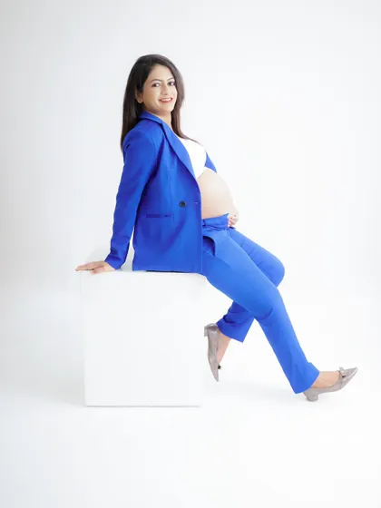 A powerful and chic "boss mama" look. This portrait features a stylish royal blue suit, showing that pregnancy is a time of strength and confidence.