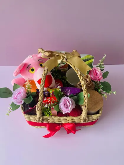 A close-up of the birthday hamper, showcasing the mix of toys, snacks, and decorative flowers.