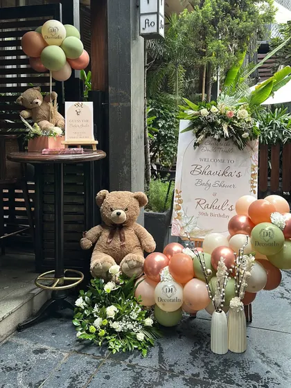 The full entrance setup, with a large teddy bear and floral arrangements complementing the welcome sign.