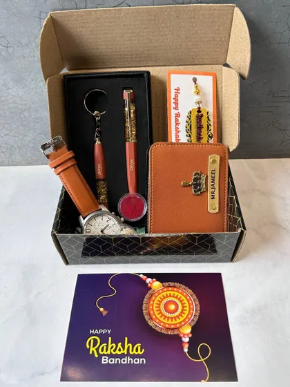 A stylish Rakhi gift set for a brother. It features a personalized watch, wallet, pen, and keychain, all neatly arranged in a gift box with a Raksha Bandhan card.