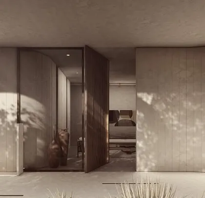 The entrance to the House of Veils, where a large pivoting door opens into a corridor of curving, textured walls. The play of light and shadow from the surrounding trees creates a dramatic and welcoming first impression.