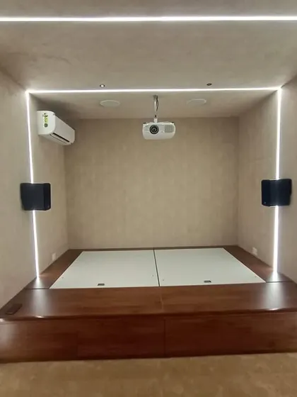 The completed room, with the raised wooden platform and mattress ready for a movie marathon. The projector is ceiling-mounted to save space.