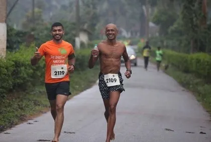 Two runners sharing a smile on the course. The Barefoot Marathon is about camaraderie and enjoying the journey together.