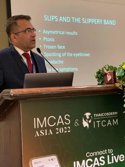 Lecturing on the potential complications of botulinum toxin treatments at IMCAS Asia in Bangkok, emphasizing the importance of safety and management.