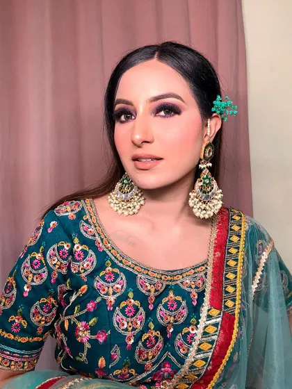 Another angle of this purple smokey eye look. The kohl-rimmed eyes add intensity, while the large chaandbali earrings frame the face and complement the festive, colorful outfit.