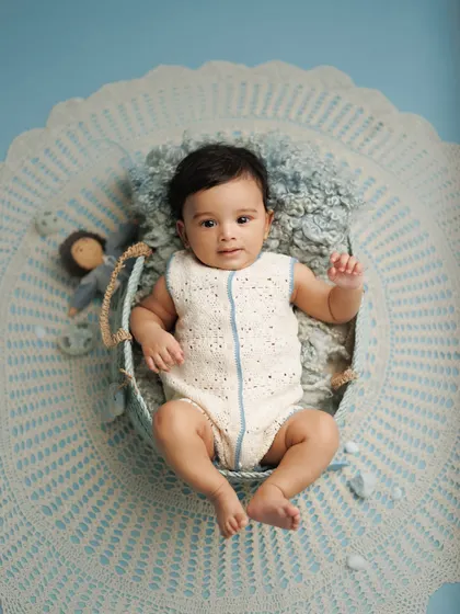 Four months of wonder. This baby boy looks so calm and curious in a blue-themed setup, showing how I use color and texture to create beautiful, composed milestone portraits.