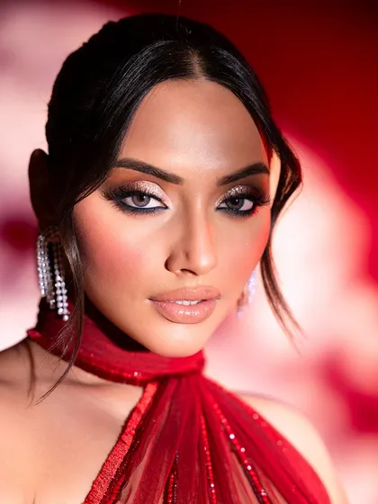 A close-up on cocktail glamour. The smokey eye makeup and cascading diamond earrings perfectly complement the bold red gown, showcasing my attention to every detail of the final look.