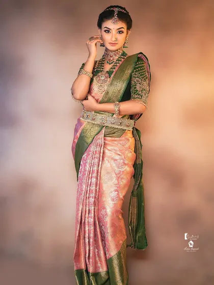 A full-length view of a traditional bride. Understanding how to drape the saree and place the jewelry is just as important as the makeup itself.