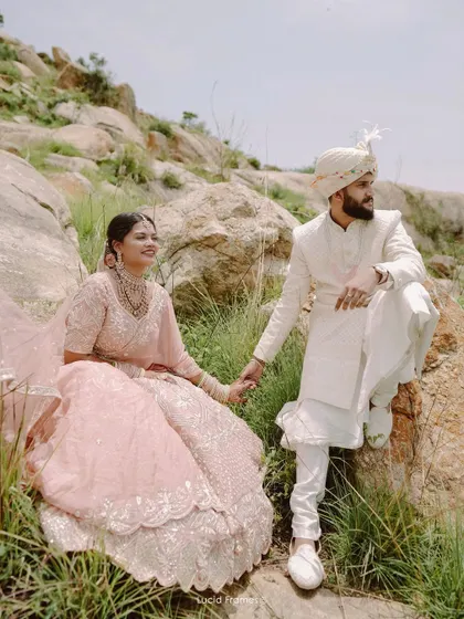A regal pose amidst a rocky landscape, blending traditional attire with the raw beauty of nature for a unique pre-wedding album.