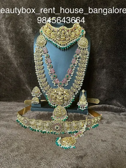 An antique-finish bridal set with a choker, a layered haaram, and a matching peacock-motif vaddanam.