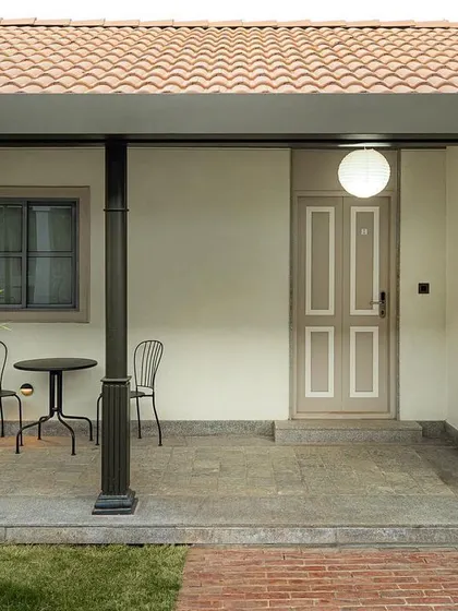 The entrance to a guest suite at Samavana, featuring a simple portico and a classically designed door. These details contribute to the venue's timeless, vernacular-inspired aesthetic, offering a comfortable and elegant experience for guests.