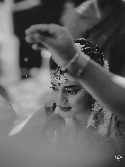 A stunning black and white close-up of the bride during a wedding ritual, her expression serene.