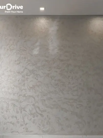 This wall features a completed Halo Dune texture, which offers a soft, swirling pattern with a gentle shimmer. The effect, enhanced by overhead lighting, provides a sophisticated and modern finish ideal for living rooms.