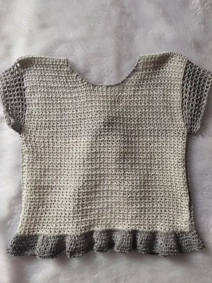 A flat-lay of the back of the Orchid Top, showing the solid back panel and mesh sleeves.