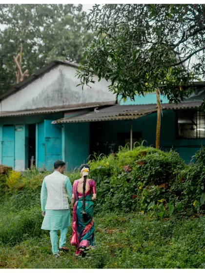 A shot of a couple walking away hand-in-hand towards a rustic house, creating a sense of starting a new journey together.