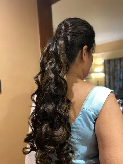 Another view of the curly ponytail, a fun and chic option for any pre-wedding celebration.