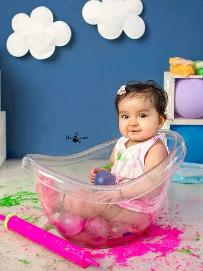 This baby girl is all smiles during her Holi themed bath time. It is a fun and unique way to capture photos.