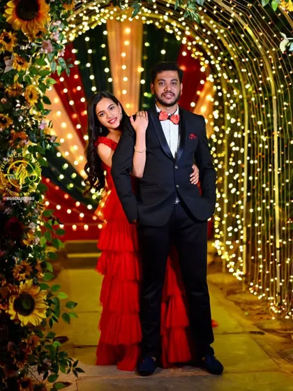 A vibrant night-time pre-wedding shoot. I styled the couple with a stunning red tiered gown for her and a sharp tuxedo with a bow tie for him, creating a look that pops against the festive lights.