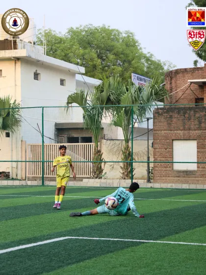 A goalkeeper makes a crucial save, holding onto the ball securely. Strong hands and quick reflexes are skills we develop through repetitive, specialized drills.