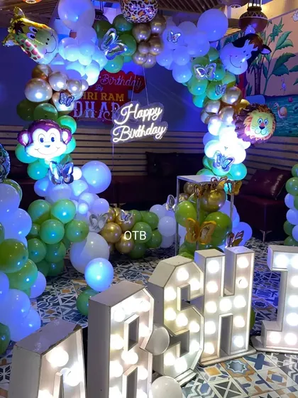 A closer look at the jungle theme balloon arch, with monkey and lion foil balloons peeking out from the arrangement.