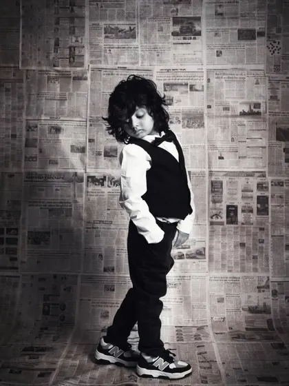 A thoughtful black and white portrait, capturing a quiet moment and the beautiful details of his outfit.