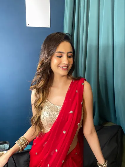 A gorgeous look in a classic red saree. The makeup is soft and glowing, with a focus on defined eyes and a natural lip.
