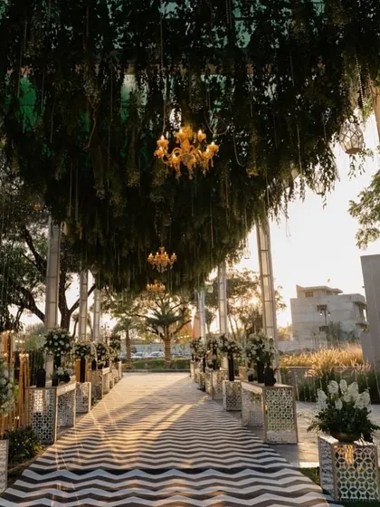The guest experience begins the moment they arrive. We create grand, immersive entrances like this one, using lush greenery, elegant chandeliers, and a striking patterned walkway to build anticipation and make a powerful first impression for your conference or corporate retreat.