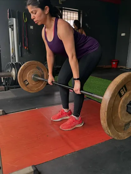 A client performs a barbell deadlift, a cornerstone of my strength programs. This exercise is fantastic for building overall strength and power.