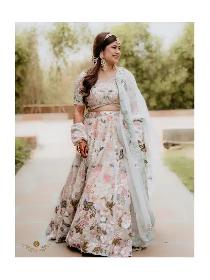 A stunning solo portrait of the bride in her floral lehenga. This shot, taken during her Jim Corbett haldi event, captures her grace and beauty.