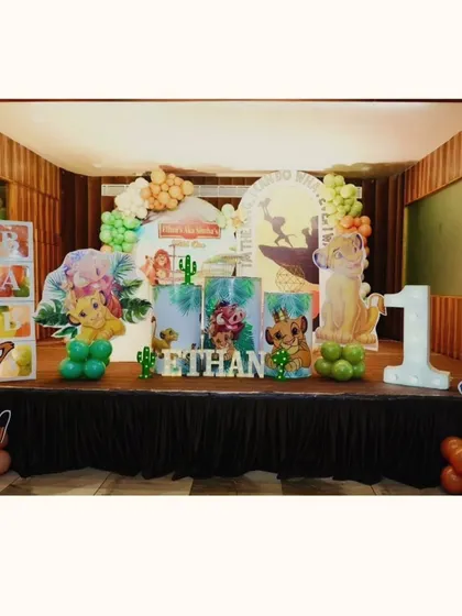 Ethan's "Wild One" party was a tribute to The Lion King, featuring characters like Simba and Timon. The stage setup includes themed plinths and a large light-up number "1" to celebrate the little king's big day.