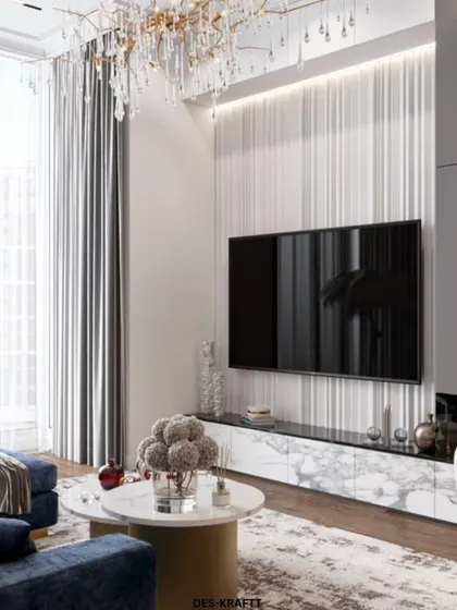 A closer look at the entertainment wall, featuring a fluted white panel design that adds texture and conceals wiring, set above a sleek marble and gold console.