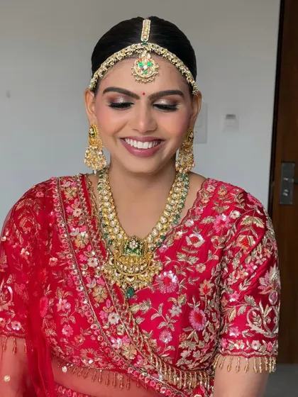 This bride chose a sleek and clean bun for her Pheras. The simplicity of the hairstyle allows her stunning red lehenga and traditional jewellery to take center stage.