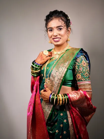 A full view of the bride's green Nauvari look against a simple background, making her outfit pop.