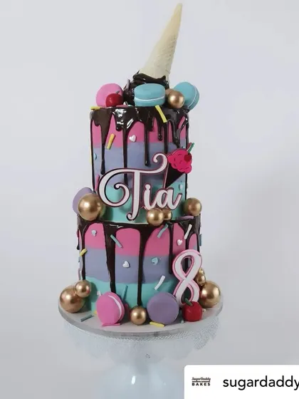 An ice cream and macaron themed cake featuring our custom layered acrylic name topper. The fun font and colors match the sweet theme perfectly.