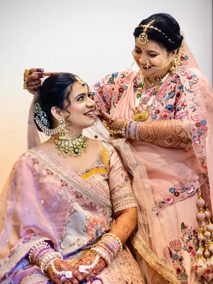 A sweet moment between the bride and her mother, who is helping her get ready.