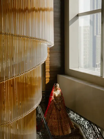 A bride standing by a grand chandelier, the light catching her regal attire. I find these unique spots for portraits that are simply breathtaking.