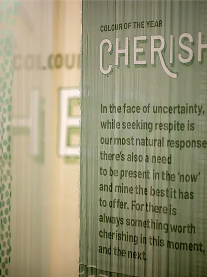 A detail from the 'Cherish' installation, where the theme is printed on a translucent fabric panel. This demonstrates our focus on integrating the narrative directly into the material palette of our experiential designs.