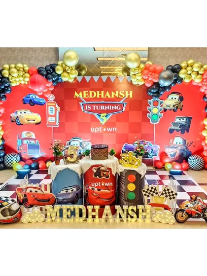 A wide view of a Cars themed 5th birthday, showing the race track floor mat and multiple character cutouts.
