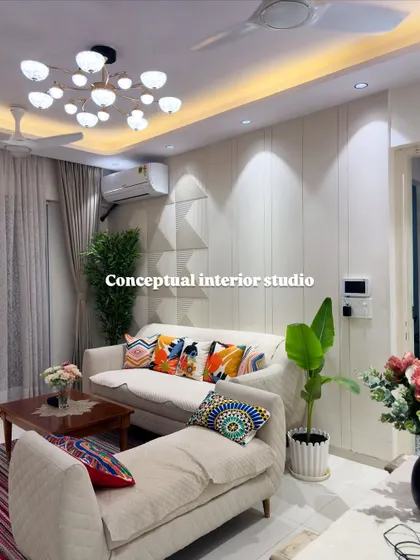 Another angle of the living room, showing the textured wall paneling and the strategic placement of plants to bring a touch of nature indoors.