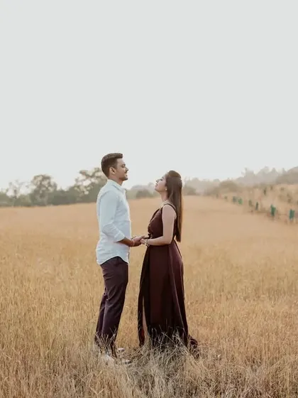 A wide shot of the couple standing in a vast field, emphasizing their connection in a beautiful, natural landscape.
