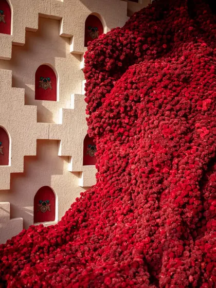 A detail of the magnificent red Baoli installation, showcasing the incredible texture created by thousands of individual Sola flowers. The piece is a testament to our commitment to large-scale, handcrafted artistry.