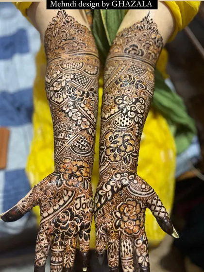 A full view of a bridal design that includes the groom's name, 'Joun', hidden in the palm.
