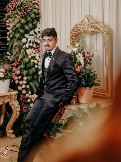 A stylish portrait of the groom in his classic black tuxedo, ready for the reception party.
