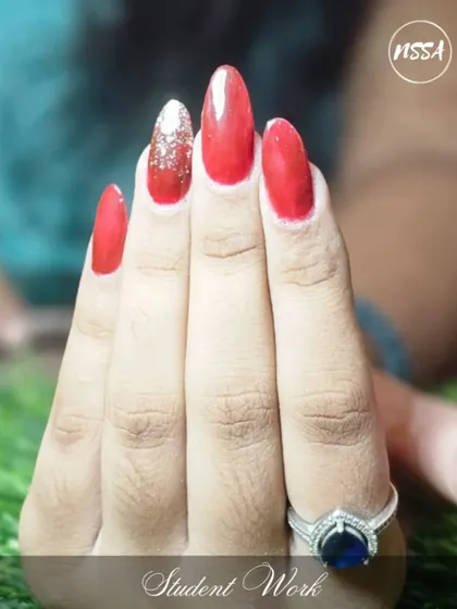 A classic red manicure with a single silver glitter accent nail. This is a powerful and confident look, beautifully done by one of my students.
