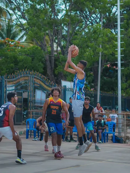 An ASB player rises for a jump shot during a Baseline Basketball League (BBL) game. The outdoor court setting tests a different kind of focus.
