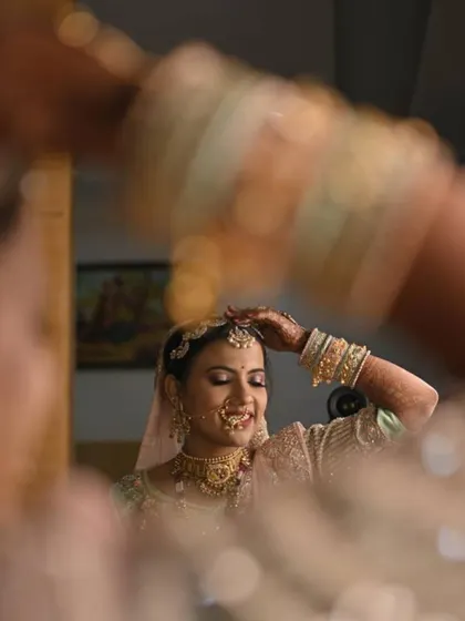 A candid moment of the bride getting ready. Her pastel lehenga is paired with soft makeup that looks beautiful in natural light.