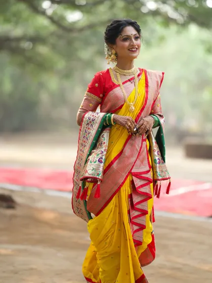 The grace of a Maharashtrian bride in motion. Her yellow Nauvari saree with its intricate Paithani border looks stunning as she walks, creating a timeless and elegant picture.