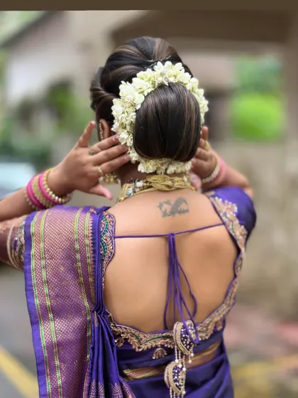 The back view, showing the classic 'khopa' hairstyle completely covered with a beautiful jasmine 'gajra'.