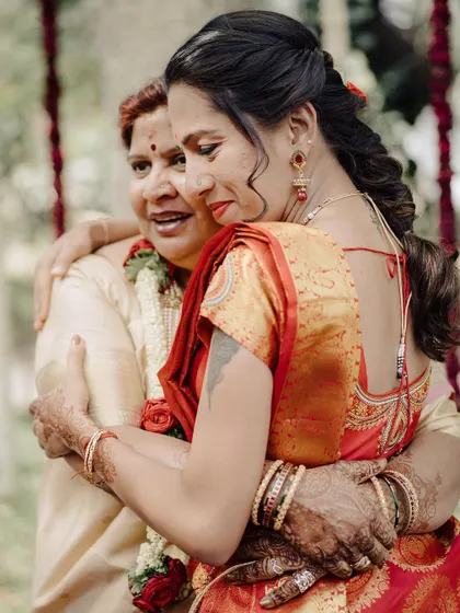 An emotional embrace between two family members. The tears and the tight hug convey a powerful story of love and connection, the kind of moment that makes wedding photography so meaningful.