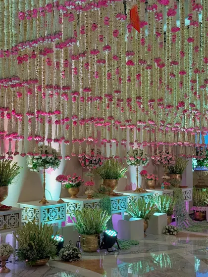 More views of the magical entrance, highlighting the density of the floral ceiling, the elegant decor pieces, and the soft, inviting lighting.